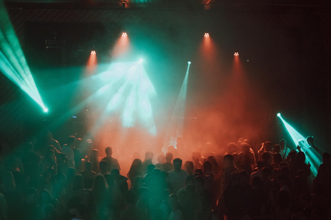 Crowd dancing under colourful stage lights at an R&B party night