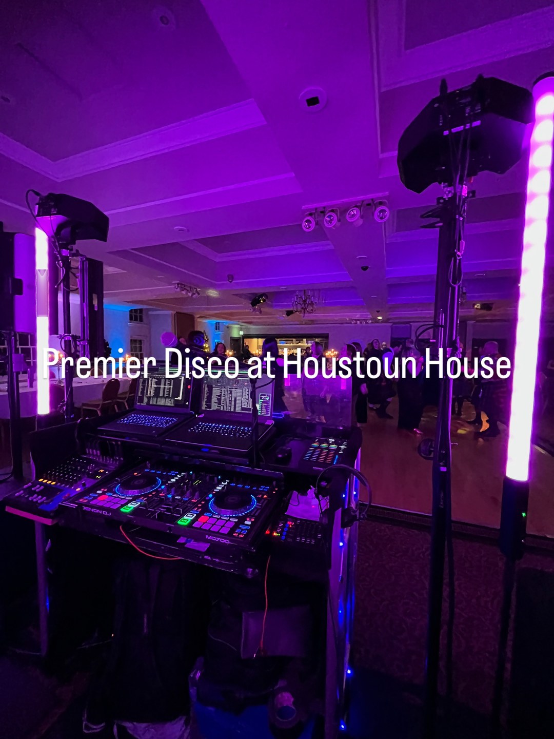 Premier Disco professional wedding DJ setup with purple uplighting, LED tube lights and guests on the dance floor