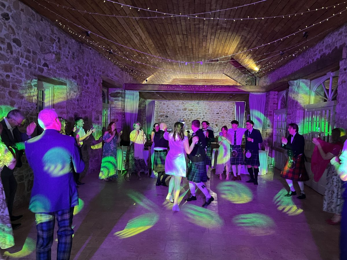 Premier Disco wedding DJ at Colstoun House, East Lothian — packed dance floor with guests in kilts under colourful lighting