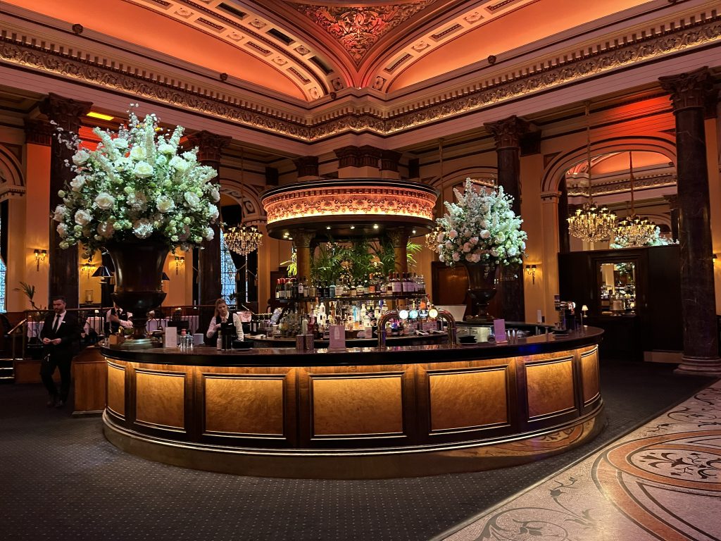 The Dome Edinburgh bar area with ornate gilded ceilings, tall floral arrangements and warm amber lighting during a corporate event — Premier Disco Scotland