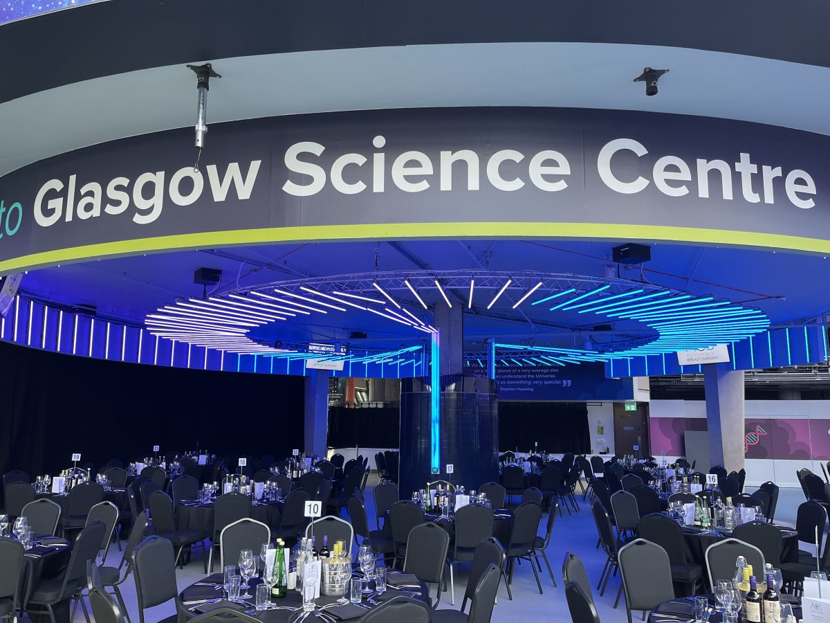 Glasgow Science Centre corporate dinner setup — round tables and stage lighting