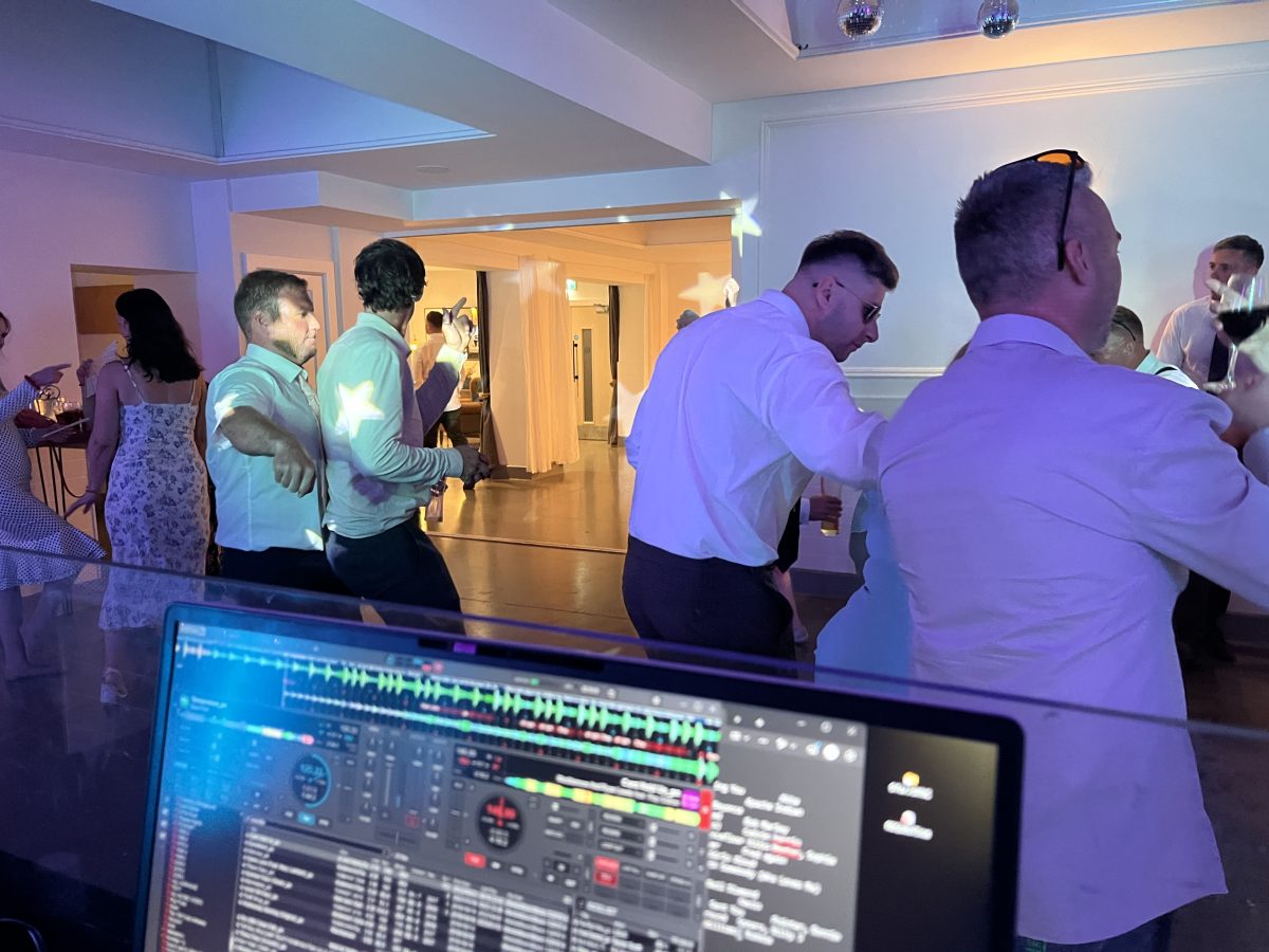 View from DJ booth at Whitekirk Hill — guests dancing under star gobo projection and purple lighting