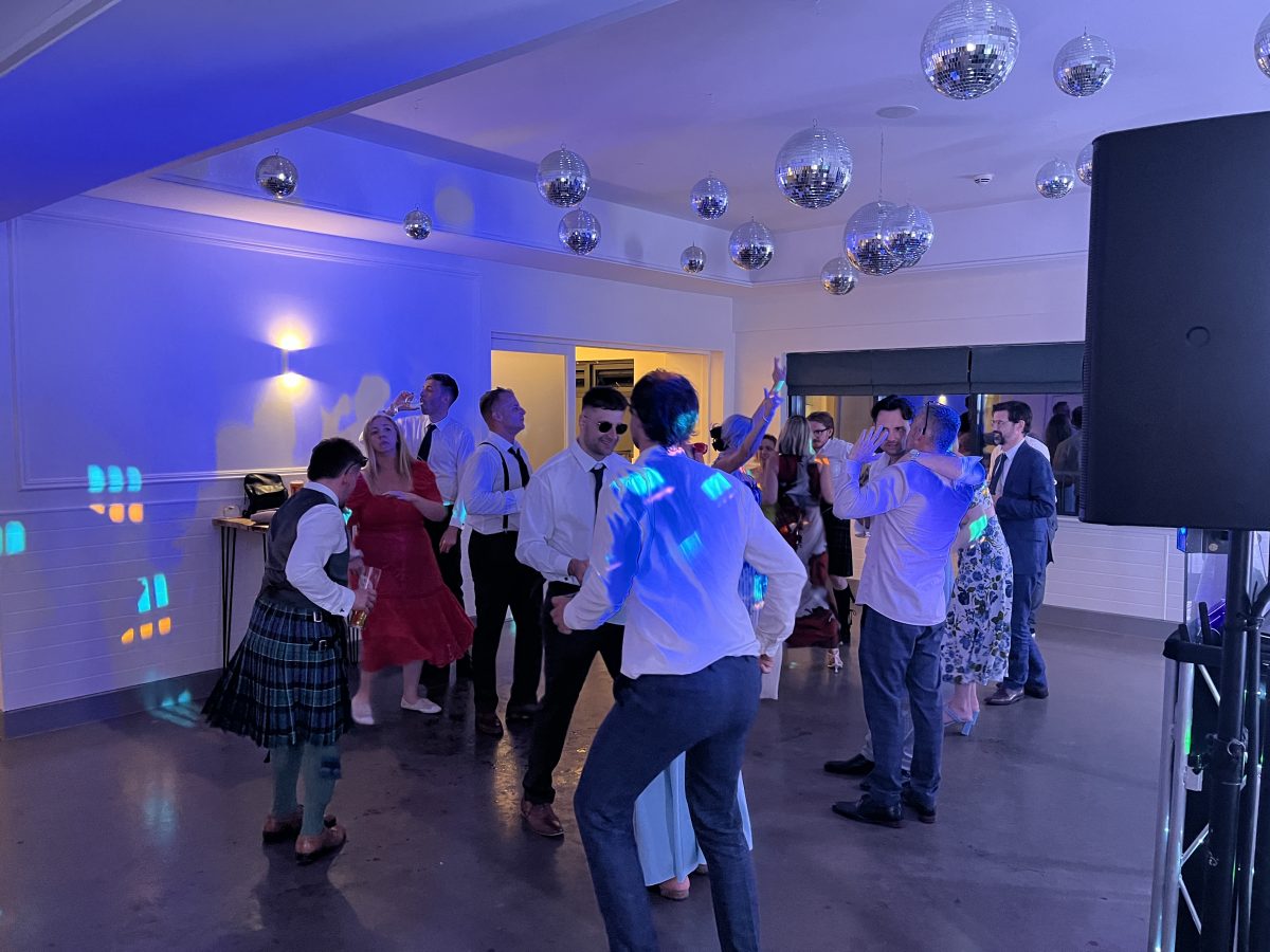Evening wedding disco in full swing at Whitekirk Hill — blue lighting and mirror balls overhead