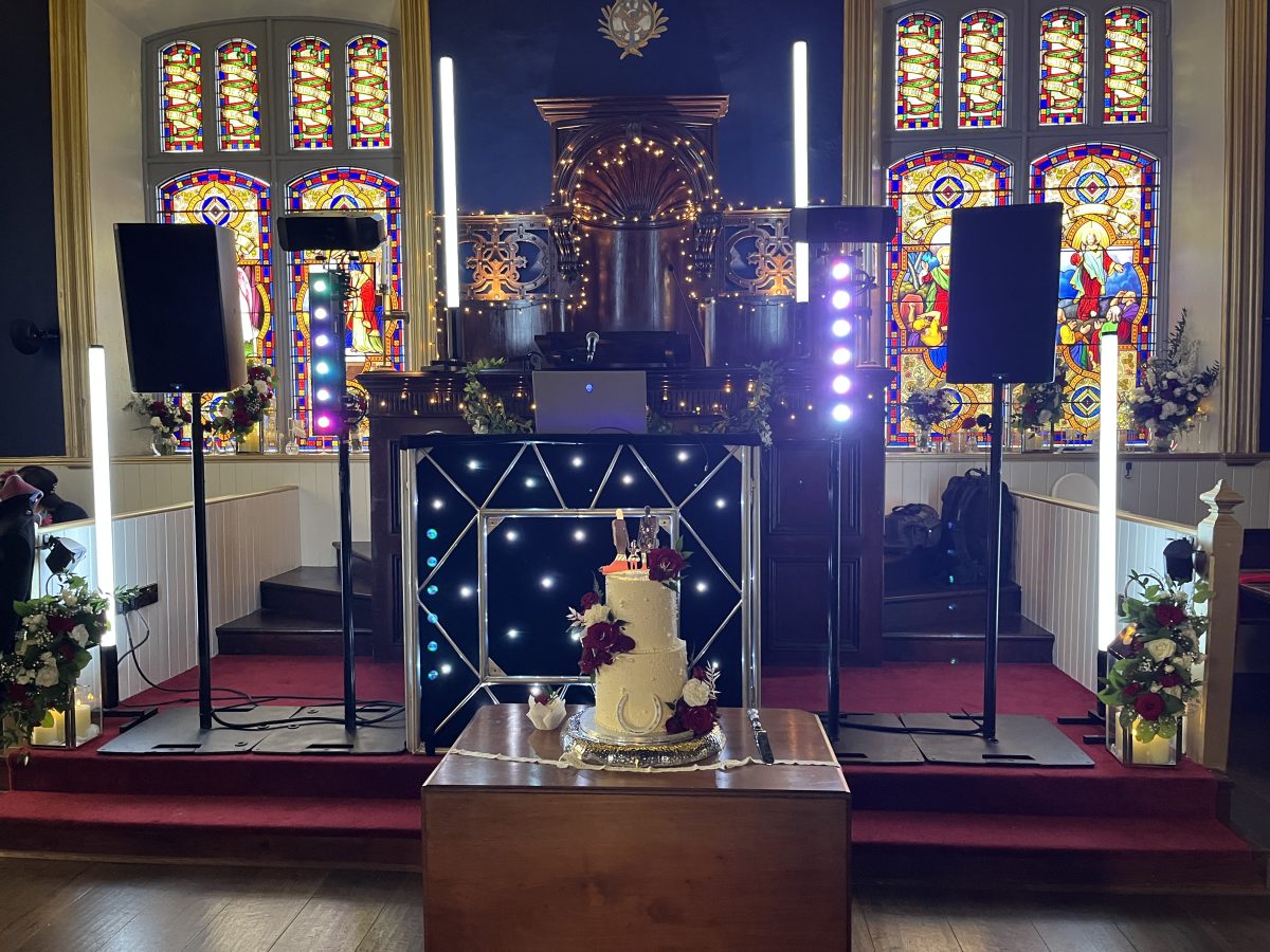 DJ set up at The Harbour Chapel Dunbar wedding with wedding cake in the foreground