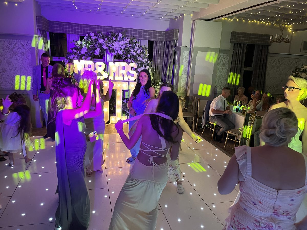 Wedding guests dancing at Stair Arms Hotel, Pathhead, under blue lighting