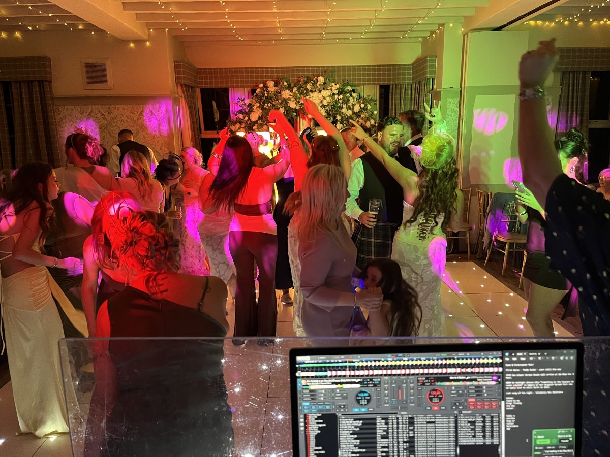 Wedding guests dancing at Stair Arms Hotel, Pathhead, with the DJ console in view